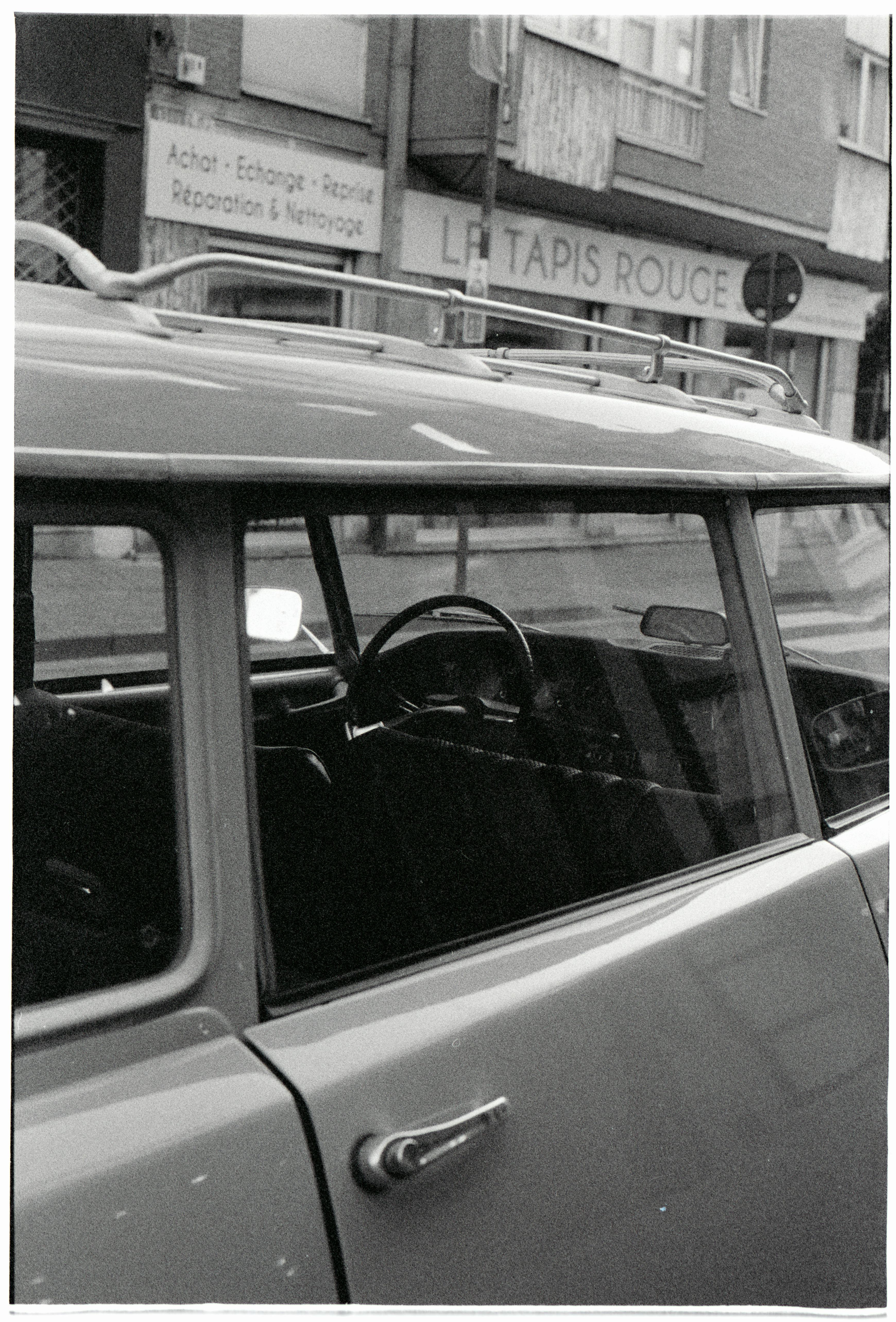 Black and white photo of a vintage car on Brussels street.