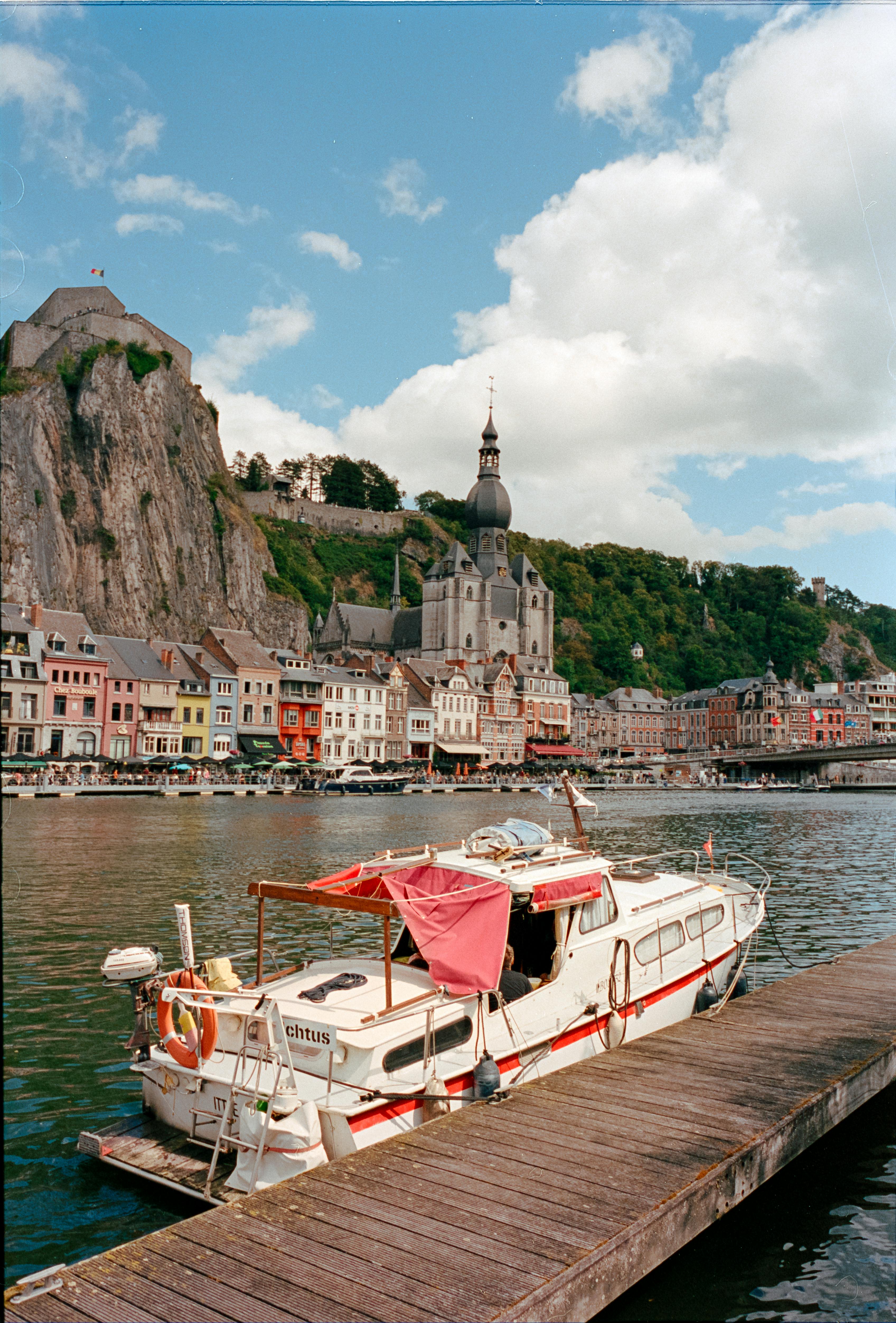 Captivating view of Dinant's waterfront with a boat and iconic architecture in Belgium.