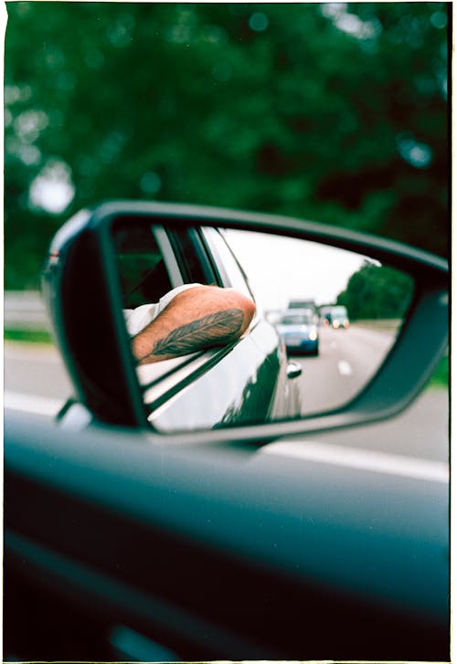 Elbow Sticking Out Car Door Reflecting in Side Mirror