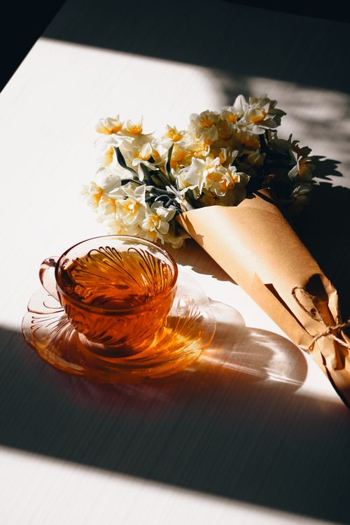 Free A delicate bouquet with a glass tea cup in warm sunlight. Stock Photo