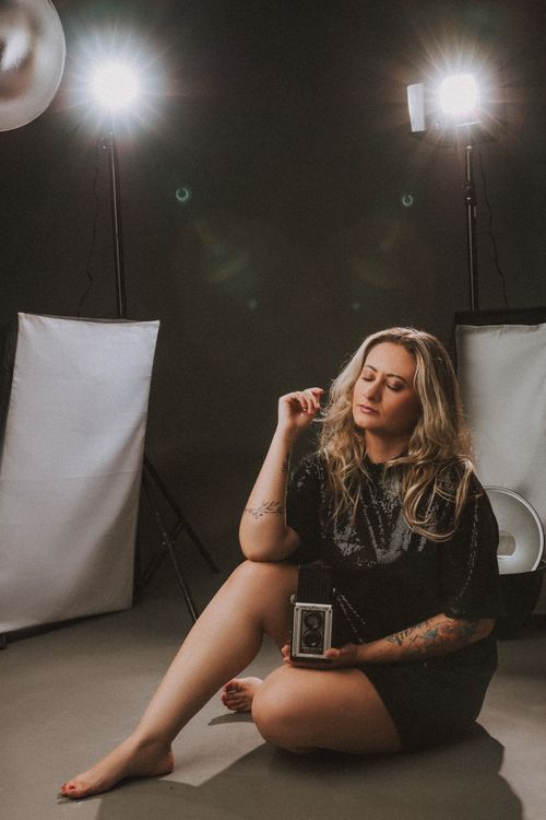 Free Artistic studio portrait of a woman with a vintage camera, capturing retro style. Stock Photo