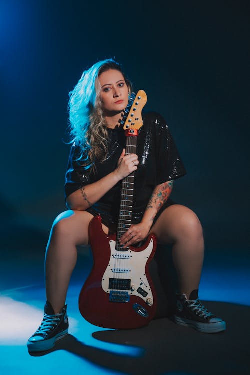 Woman Sitting with Electric Guitar