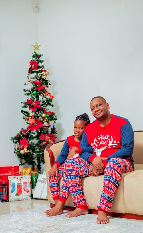 Father and Daughter Sitting by Christmas Tree