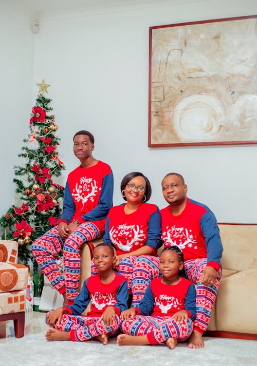 A family wearing matching pajamas and christmas tree
