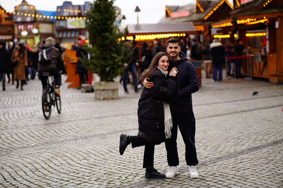 A happy couple embracing at a Christmas market