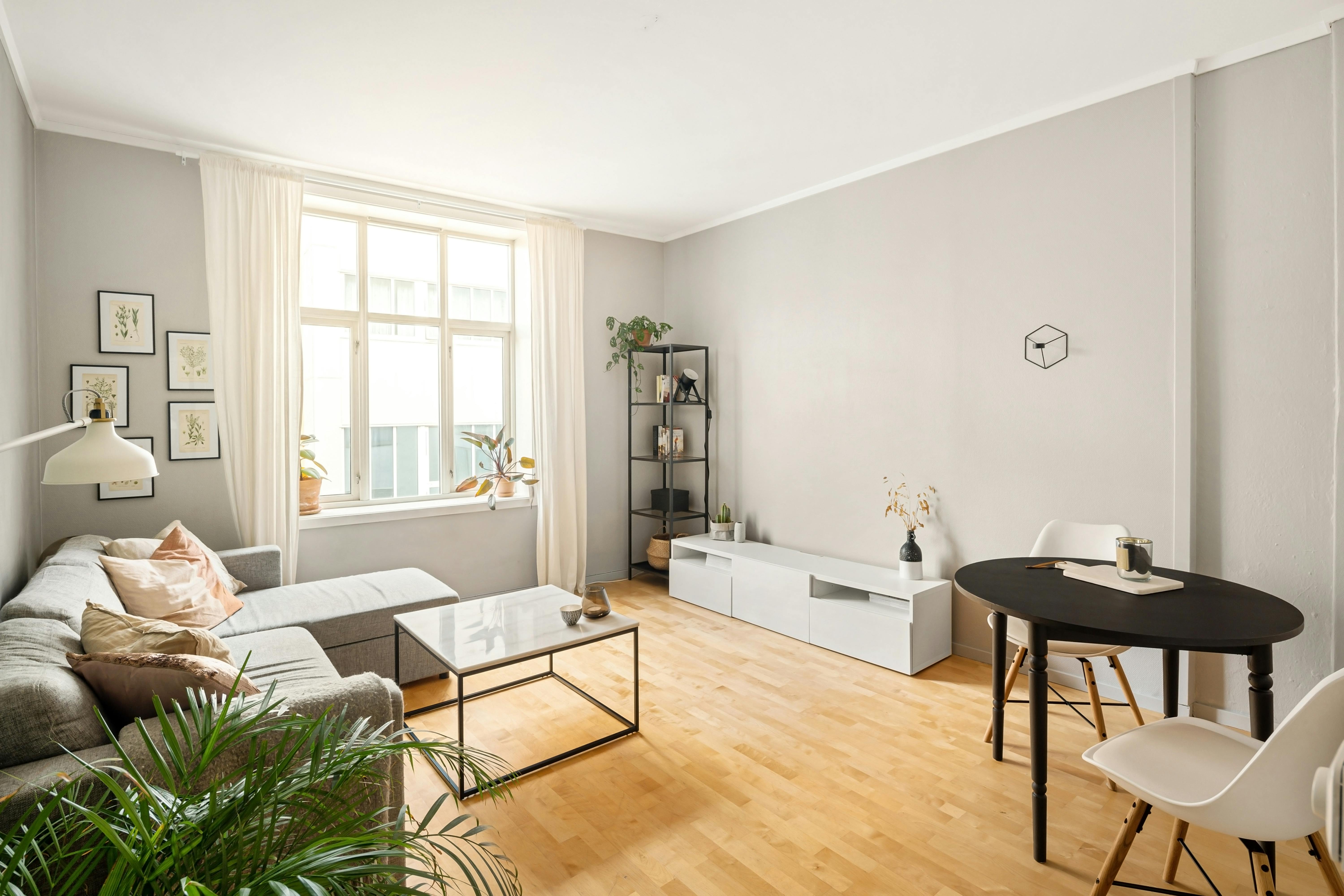 Minimalistisches Wohnzimmer mit schwebendem Wandregal und sauber ausgerichteter Befestigung an heller Wand