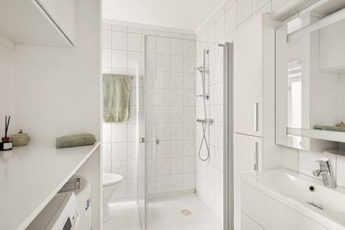 Free Bright, minimalist white bathroom featuring a sleek design with glass shower and modern fixtures. Stock Photo