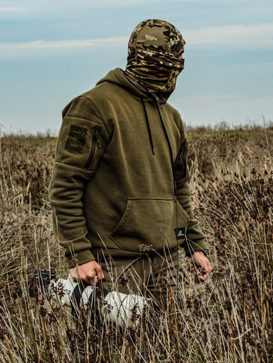 Man in a Khaki Hoodie and Camo Balaclava Standing on a Field · Free ...