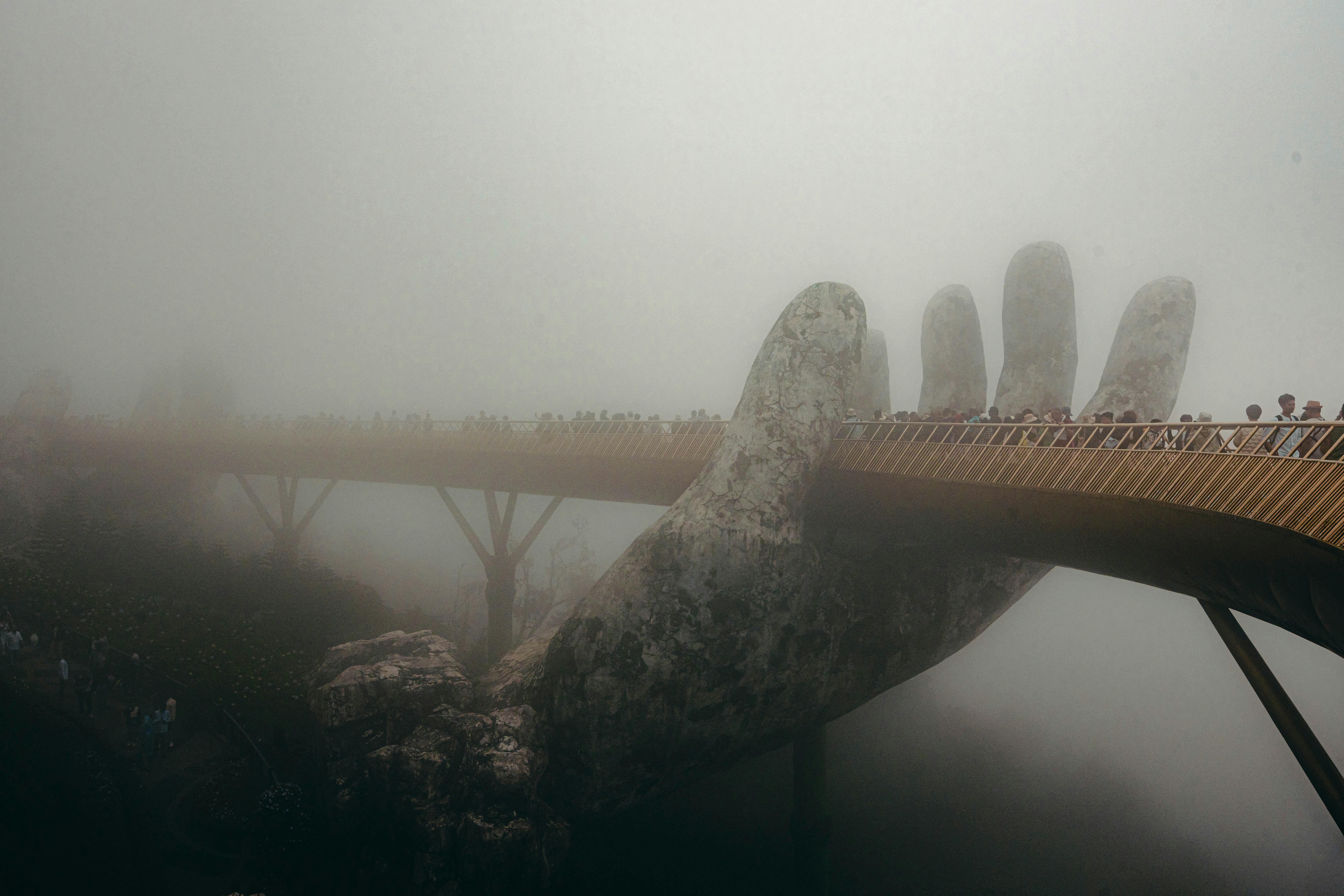 A stunning view of the Golden Bridge in Vietnam enveloped in a mystical fog, creating an ethereal atmosphere.