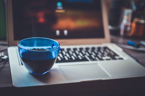 Free Blue Glass Cup on Silver Laptop Computer Stock Photo