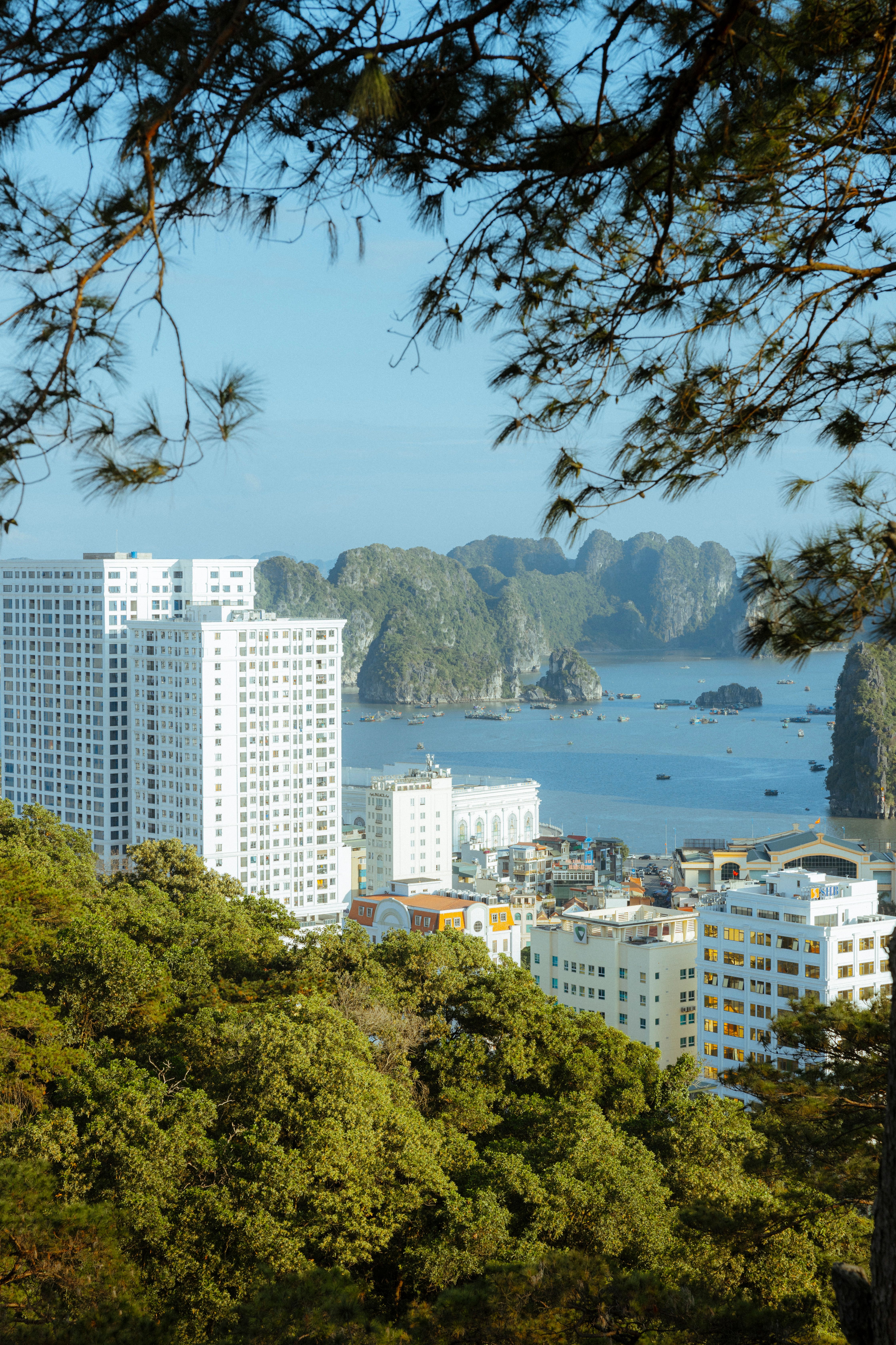 A stunning view of Ha Long Bay from above, showcasing urban buildings by the sea.