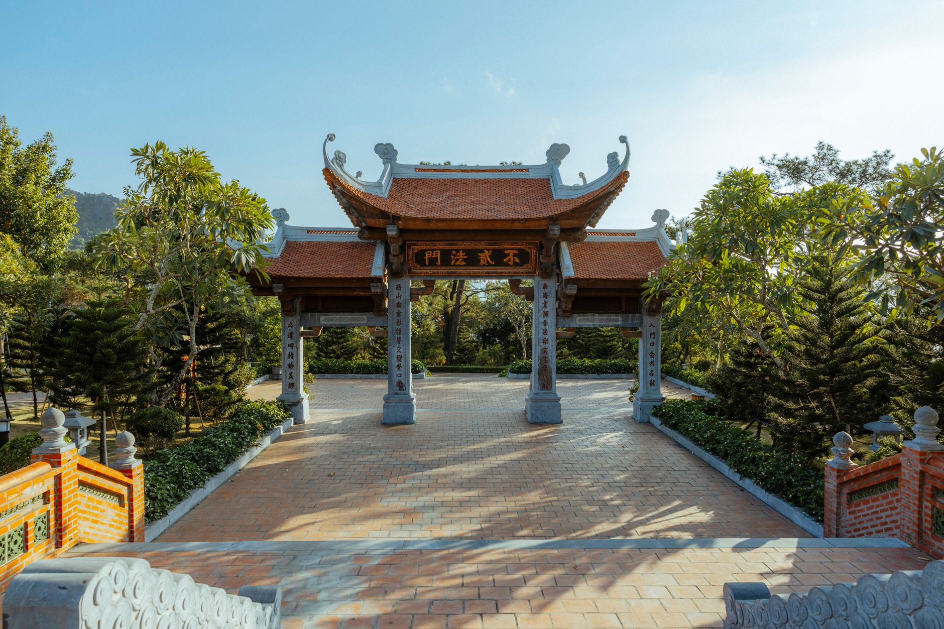 Captivating view of a Vietnamese temple entrance with traditional architecture in Ha Long, surrounded by lush greenery.