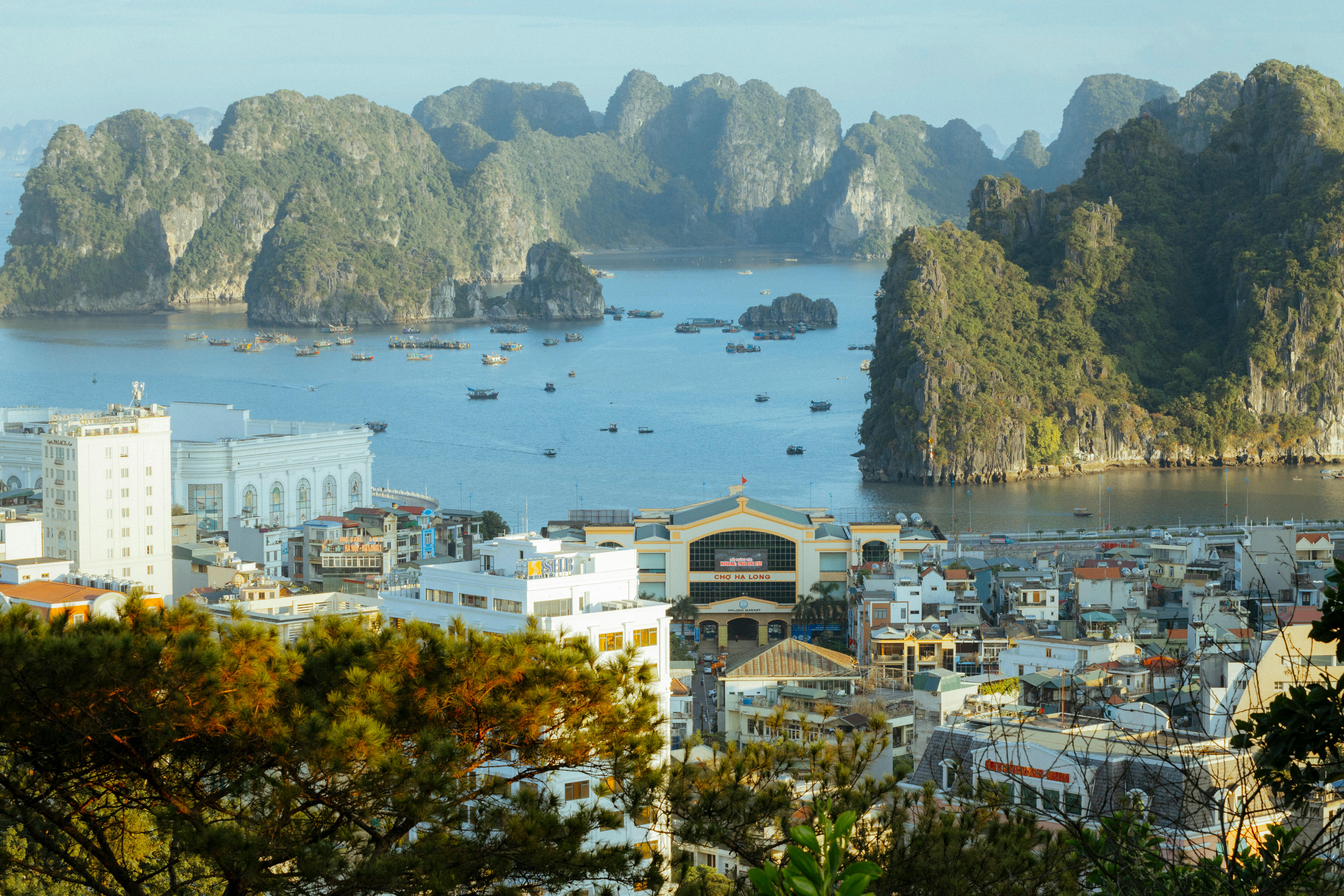 A stunning aerial view of Ha Long Bay, showcasing limestone karsts and urban landscape.