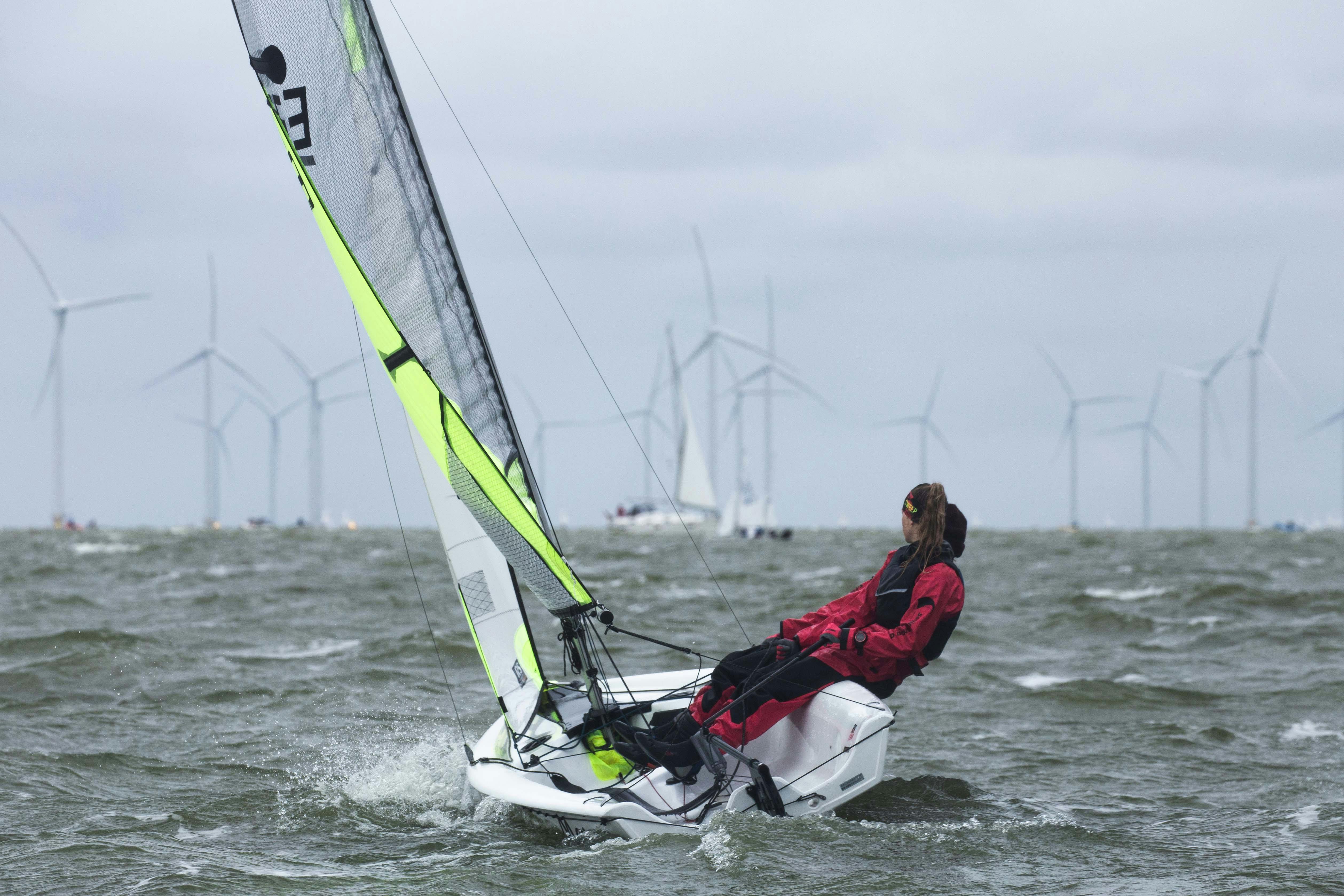 A thrilling sailing adventure with a solo sailor navigating near offshore wind turbines.