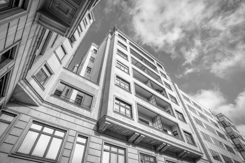 Foto en monochrome de edificios urbanos con líneas geométricas contra un cielo nublado.