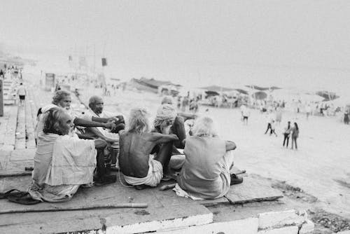 People Sitting on a Beach in Black and White 