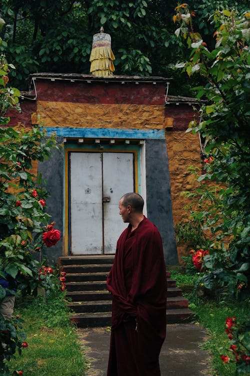Free A monk stands in front of a small building Stock Photo