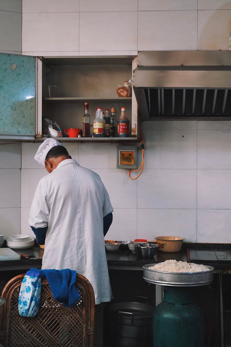 Back View Of Cook Working At Kitchen