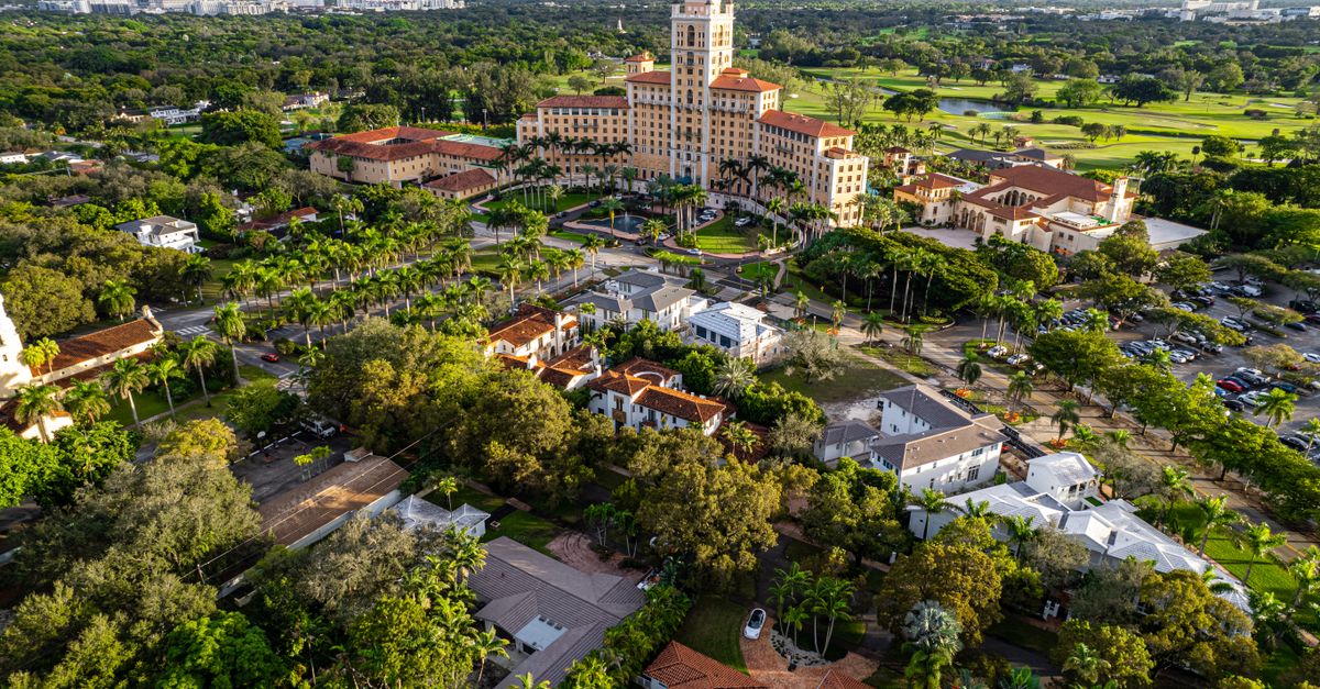 Stunning aerial shot of a luxury hotel in Miami surrounded by lush greenery and urban landscape.