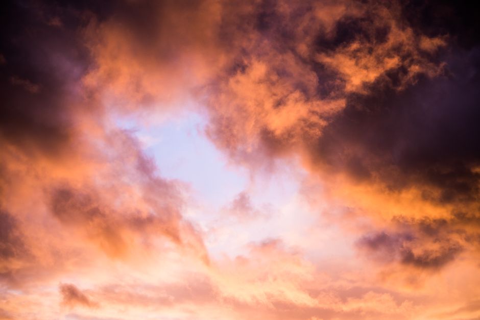 Captivating view of a dramatic sunset with vibrant orange and purple clouds.