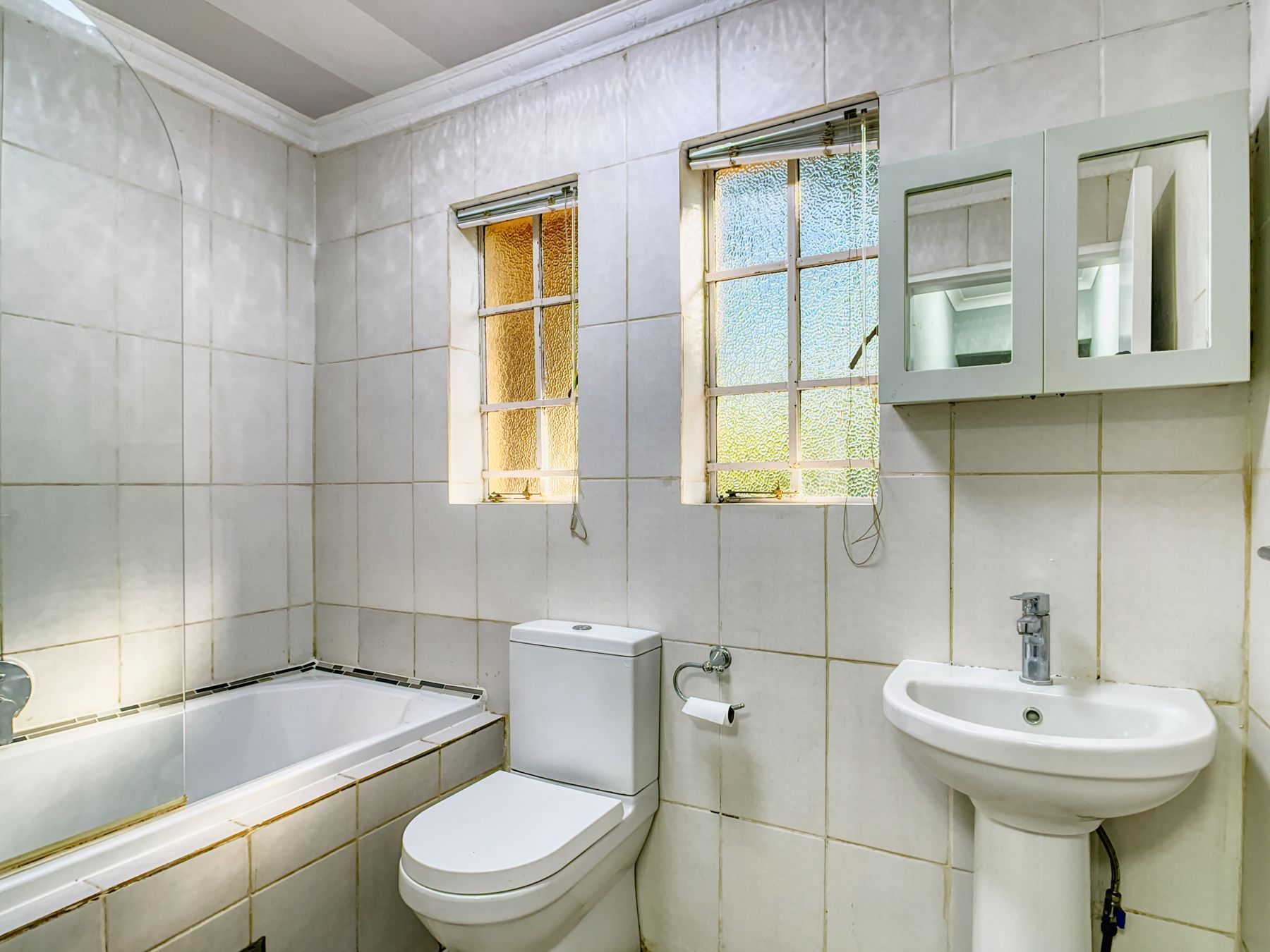 Bright bathroom with large window, pale surfaces and relaxed natural light