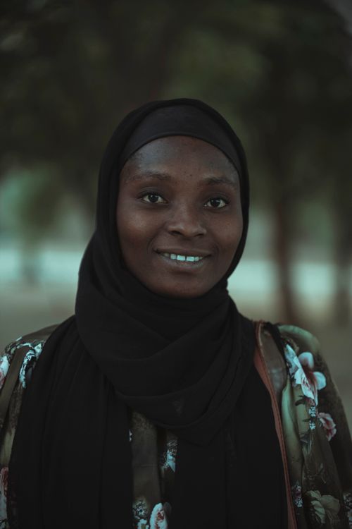 Free Charming portrait of a smiling woman wearing a black hijab outdoors. Stock Photo