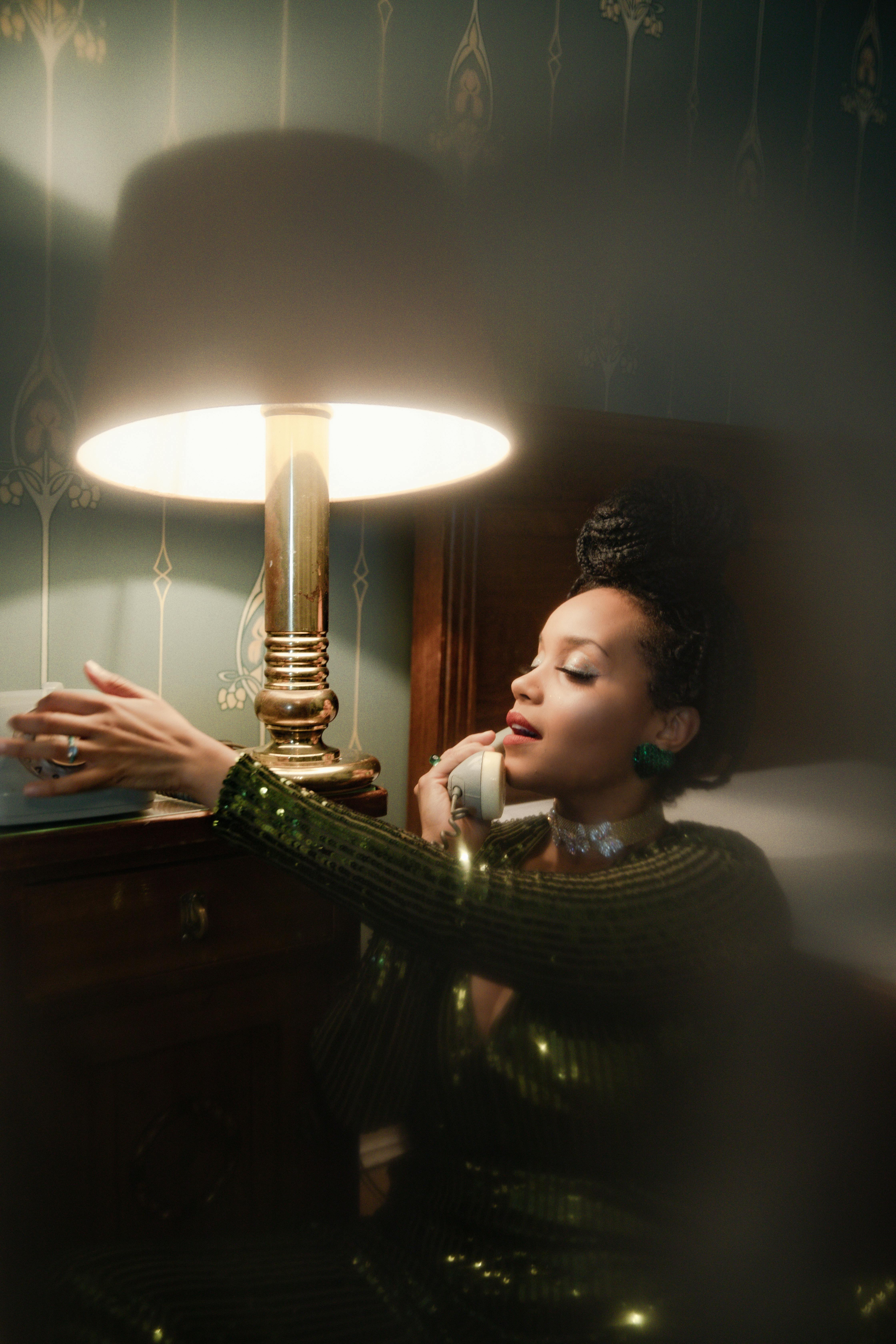 Elegant woman in a vintage room talking on the phone, emanating classic retro vibes.