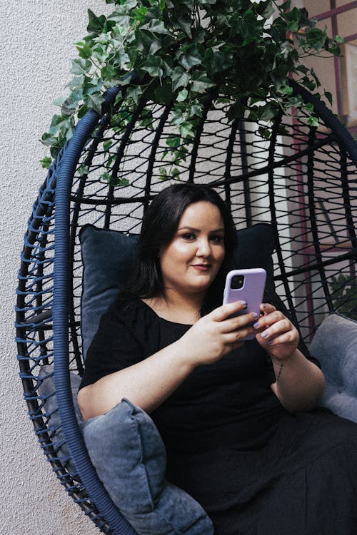 Brunette Woman with Phone Sitting on Swing