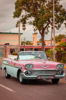 Classic pink Chevrolet convertible taxi cruising through Varadero, Cuba.