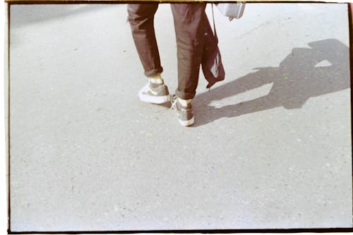 Legs of a Person Walking on the Road