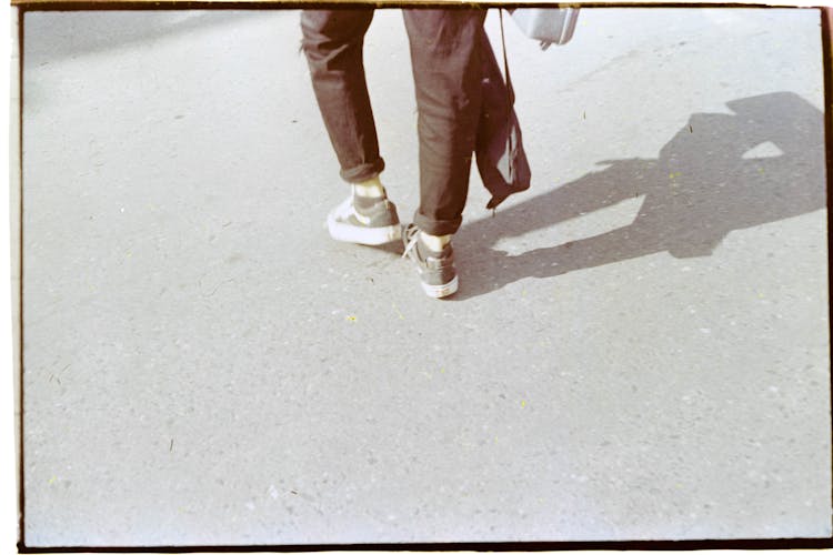 Legs Of A Person Walking On The Road