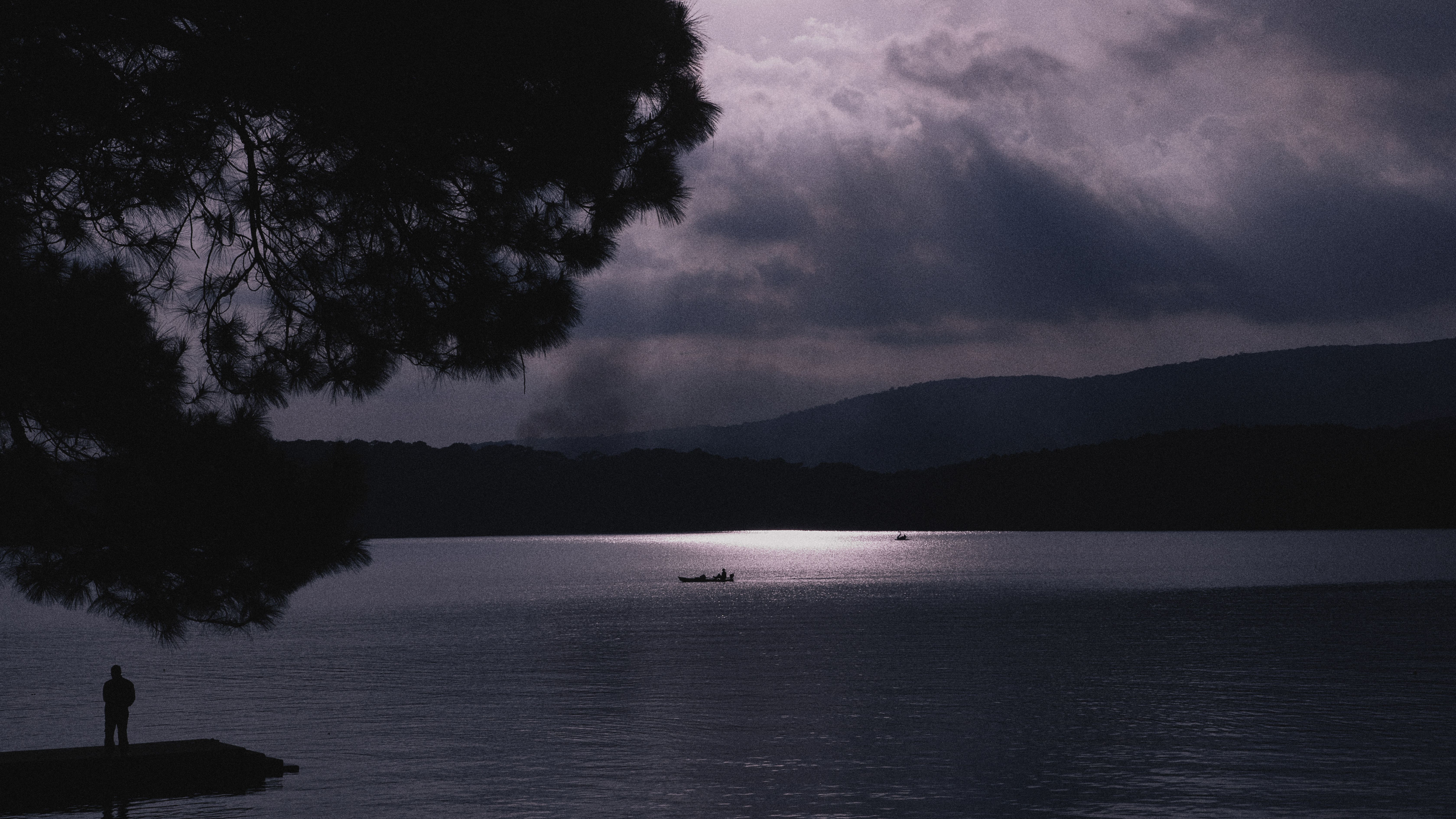 Silhouette of a Man Standing on a Lake Pier · Free Stock Photo