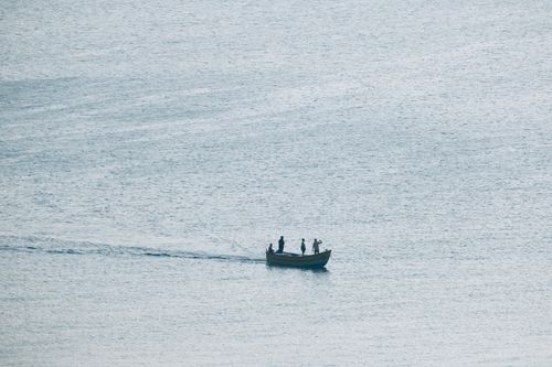 Free A serene drone shot capturing a boat floating on the tranquil waters near Kochi, India. Stock Photo