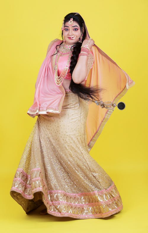Free A woman in a pink lehenga posing for the camera Stock Photo
