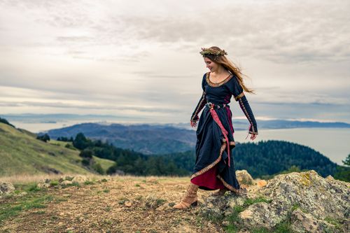 Free Woman in a traditional dress with a floral wreath, exploring a scenic hilltop in San Francisco. Stock Photo