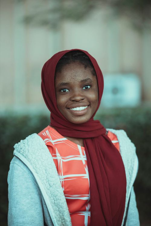 Free Smiling woman in a red scarf captured outdoors. Bright expression and stylish attire. Stock Photo