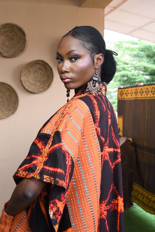 Free Portrait of an adult woman in vibrant African fashion with large earrings indoors. Stock Photo