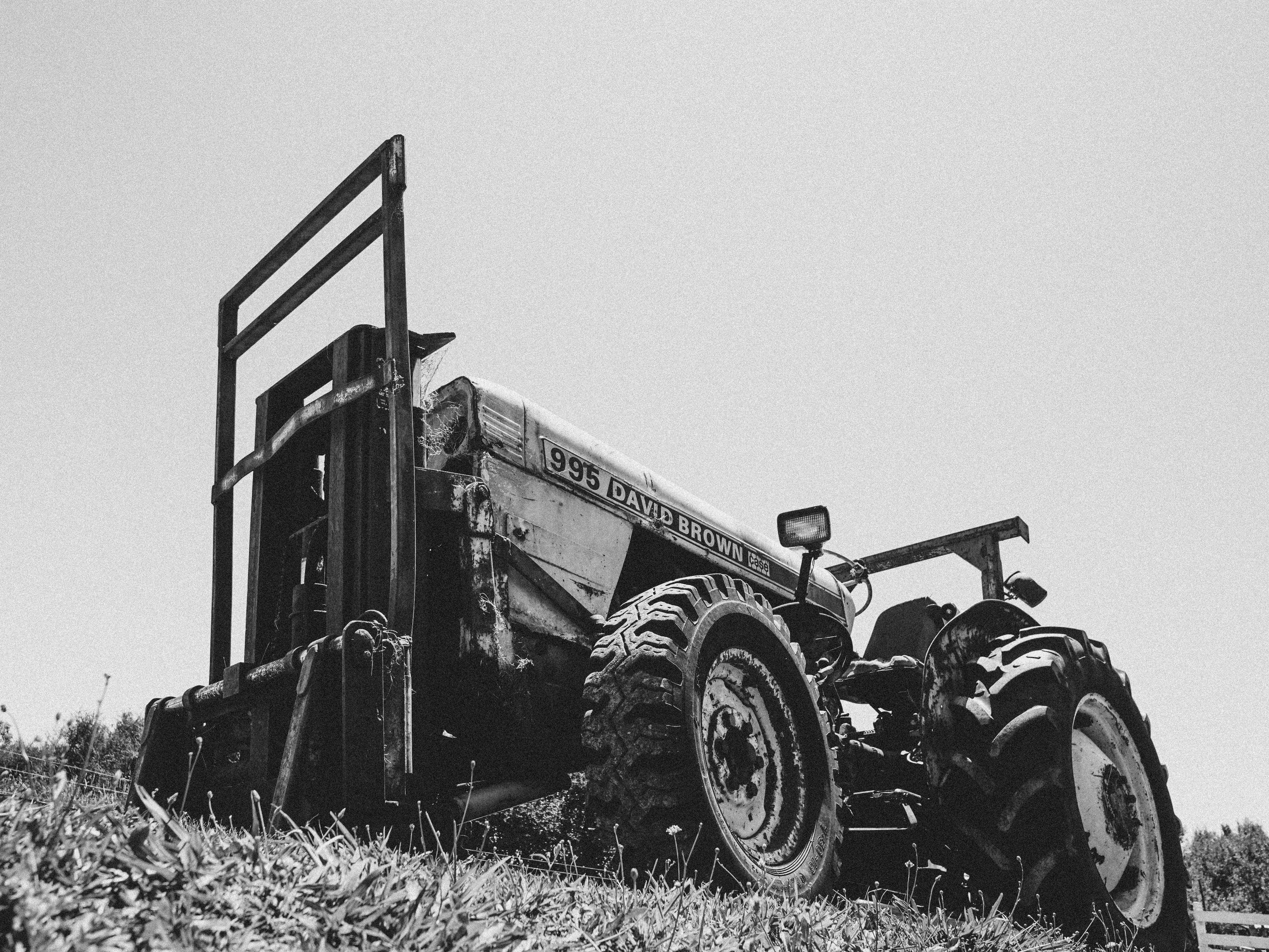 Monochrome image of a classic David Brown tractor in a field, reflecting rural life.