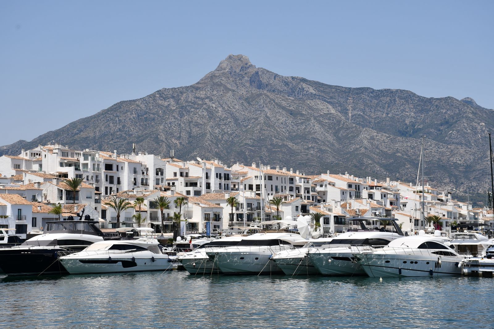 boat rental Marbella — Luxury yachts docked at Puerto Banús with mountain backdrop