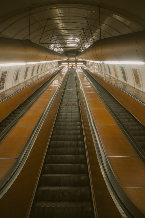 Free An empty, illuminated escalator in a modern architectural setting with symmetry and perspective. Stock Photo
