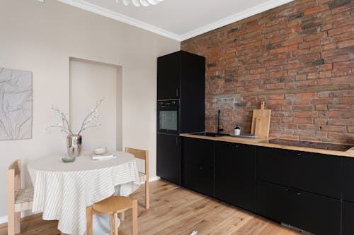 Free A kitchen with black cabinets and a brick wall Stock Photo
