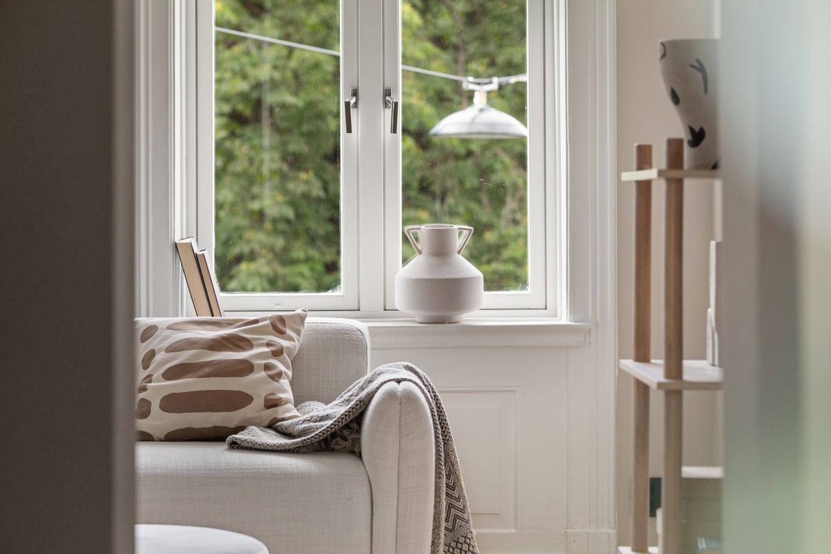 A window seat with cushions and a view of trees