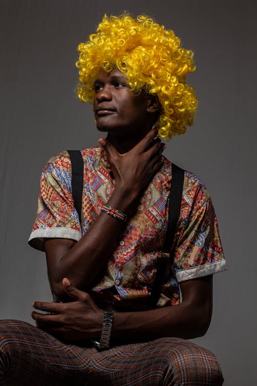 Man with Yellow Afro Hair Posing with Hand on Throat