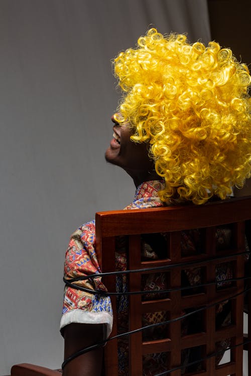 Person in Yellow Wig Sitting Tied on Chair