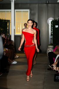 A model in a red column dress on the runway — photo by Marcus Queiroga Silva on Pexels