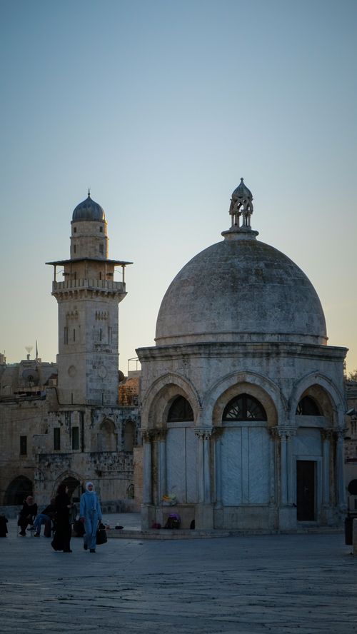 Free A picturesque view of historic Islamic architecture with a dome and minaret in Jerusalem at sunset. Stock Photo