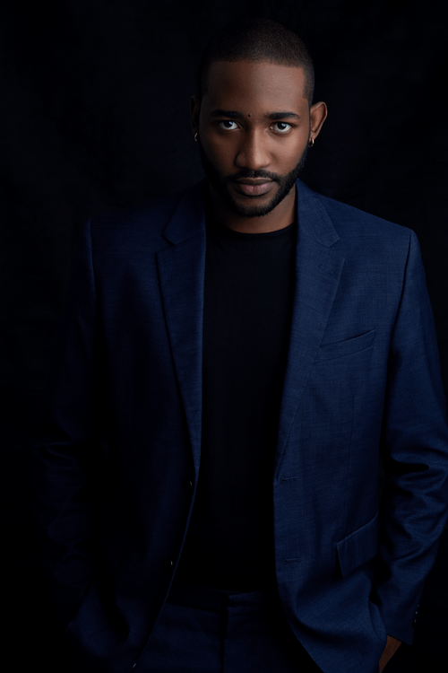 Free Sophisticated fashion portrait of a man in a blue suit with a black backdrop. Stock Photo