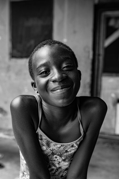Free Black and white portrait of a smiling young girl conveying joy and innocence. Stock Photo