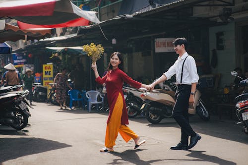 Woman in Traditional Clothing Holding Hands with Man