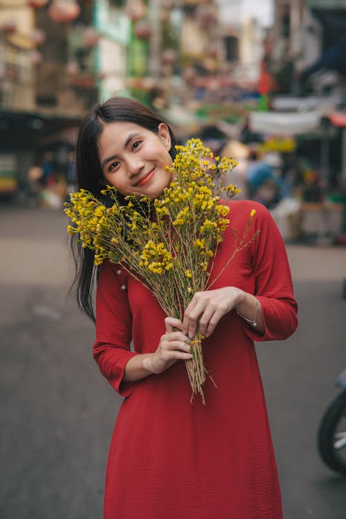 Asyalı kadın, ayakta, Çiçekler içeren Ücretsiz stok fotoğraf